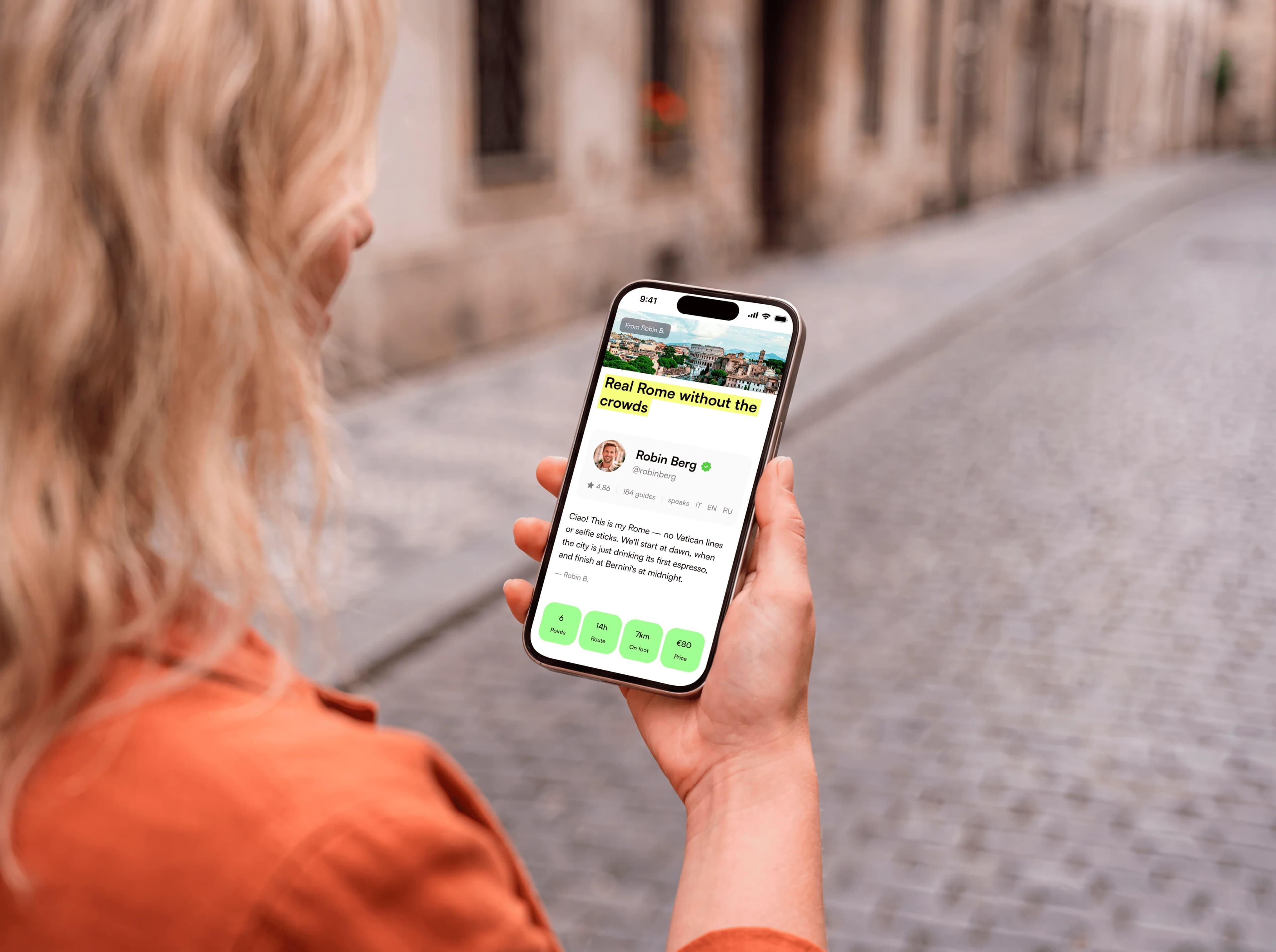 Host holding a phone with a digital guest guide on a city street